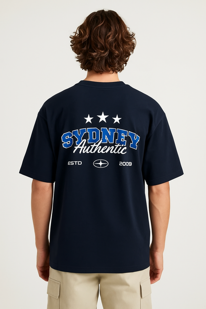 Person wearing a navy blue t-shirt with 'Sydney Authentic' text on the back, standing against a white background.