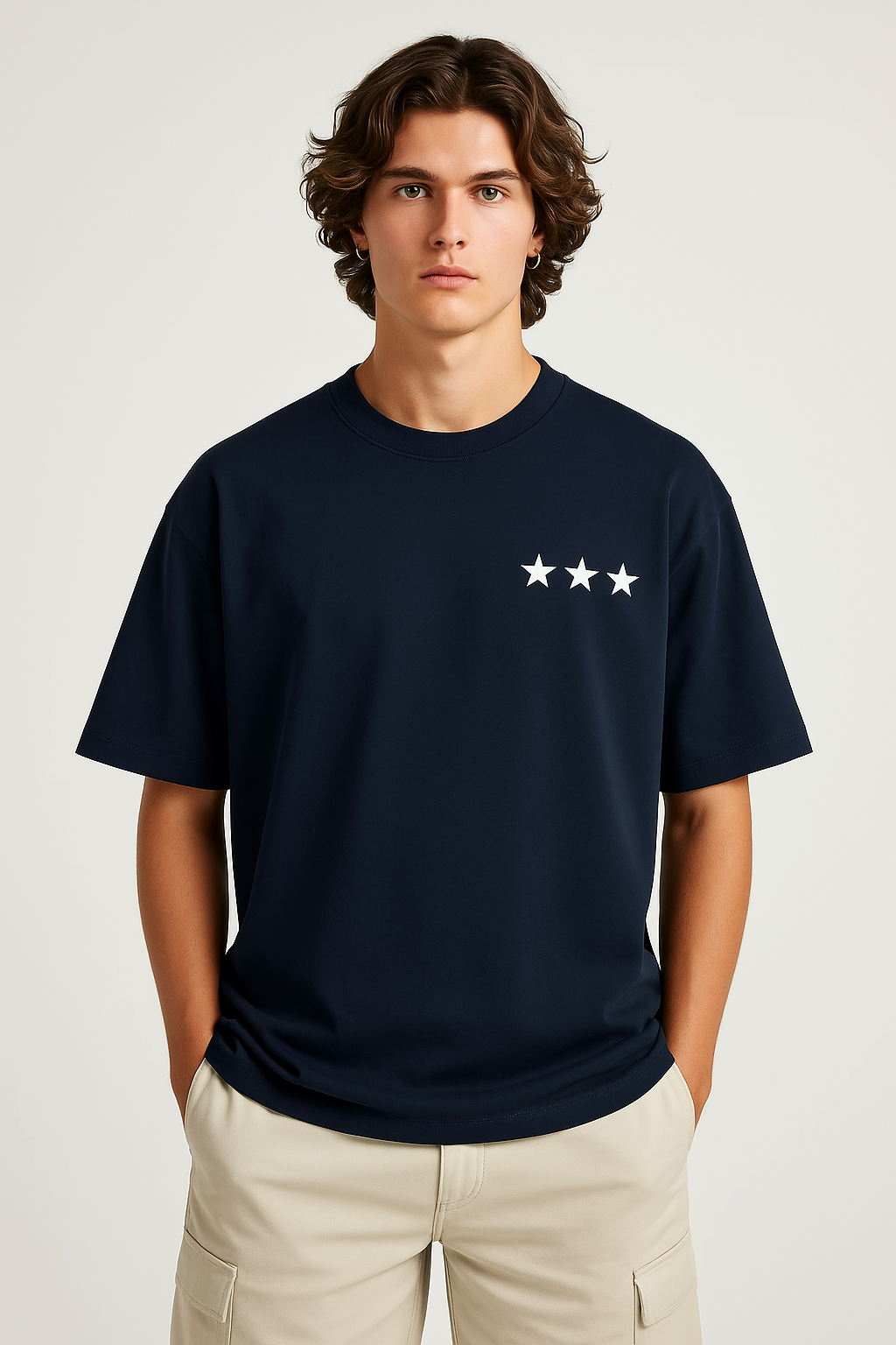 Man wearing a navy blue t-shirt with a white star design on a plain background