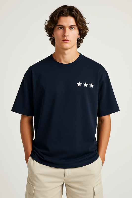 Man wearing a navy blue t-shirt with a white star design on a plain background